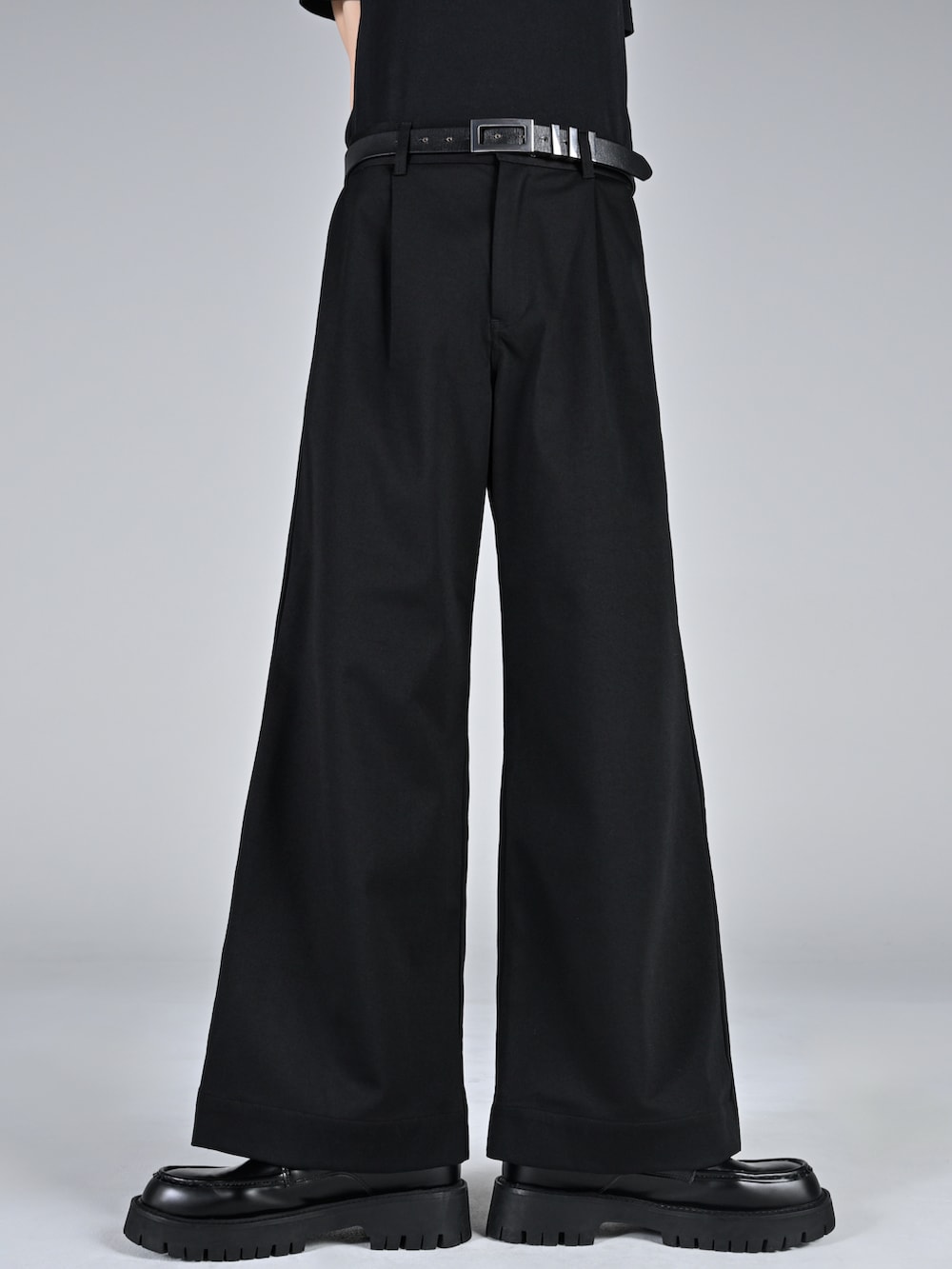 ブラック系のテーラードジャケット、レッド系のタンクトップ、ブラック系のスラックスを着用したメンズの冬コーディネートの3枚目の写真