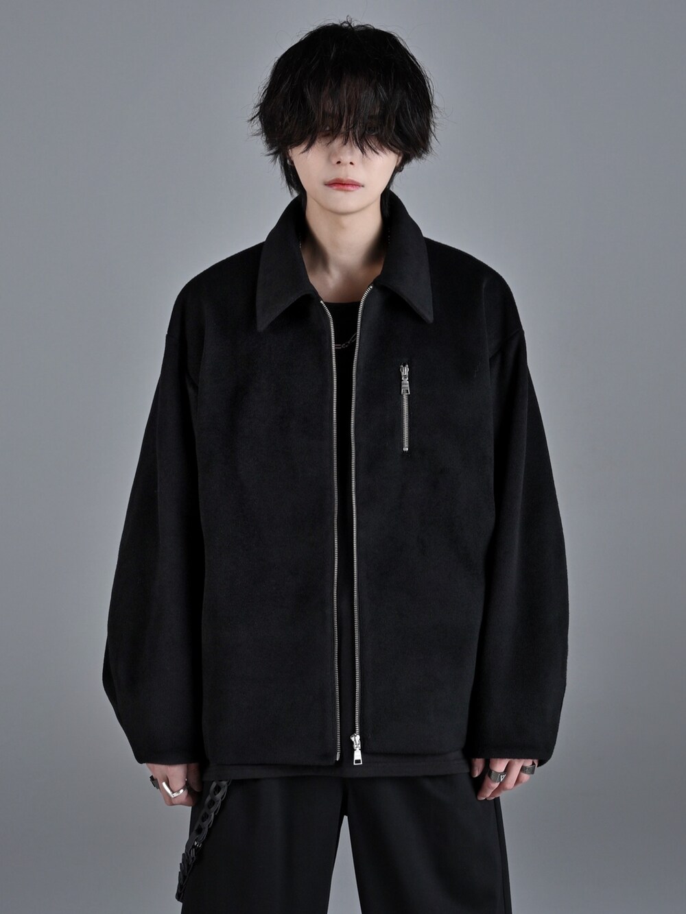 ブラック系のタンクトップ、ブラック系のスラックス、ホワイト系のスニーカーを着用したメンズの秋コーディネートの5枚目の写真