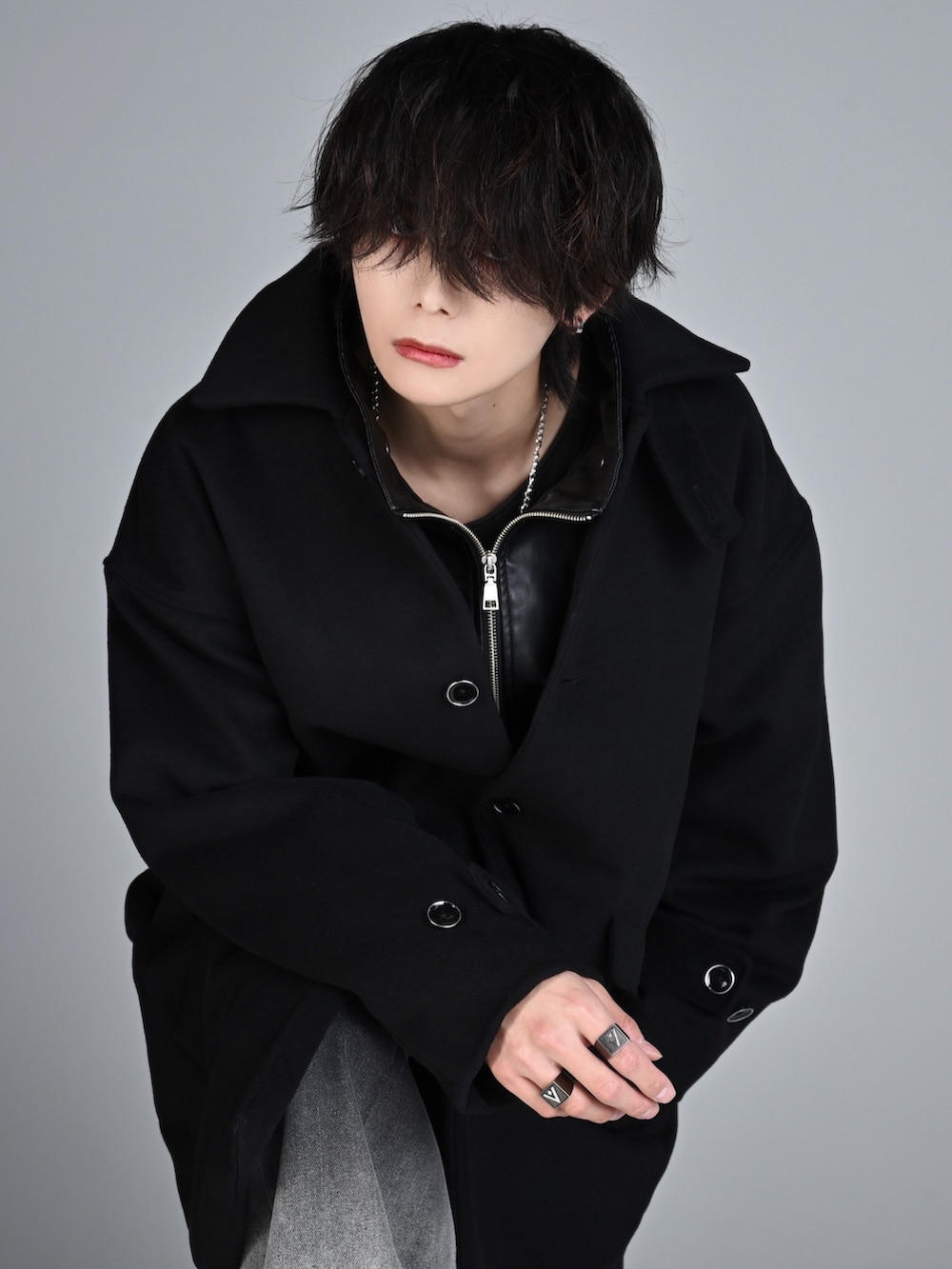 ブラック系のタンクトップ、ブラック系のブーツ、ブラック系のステンカラーコートを着用したメンズの秋コーディネートの3枚目の写真