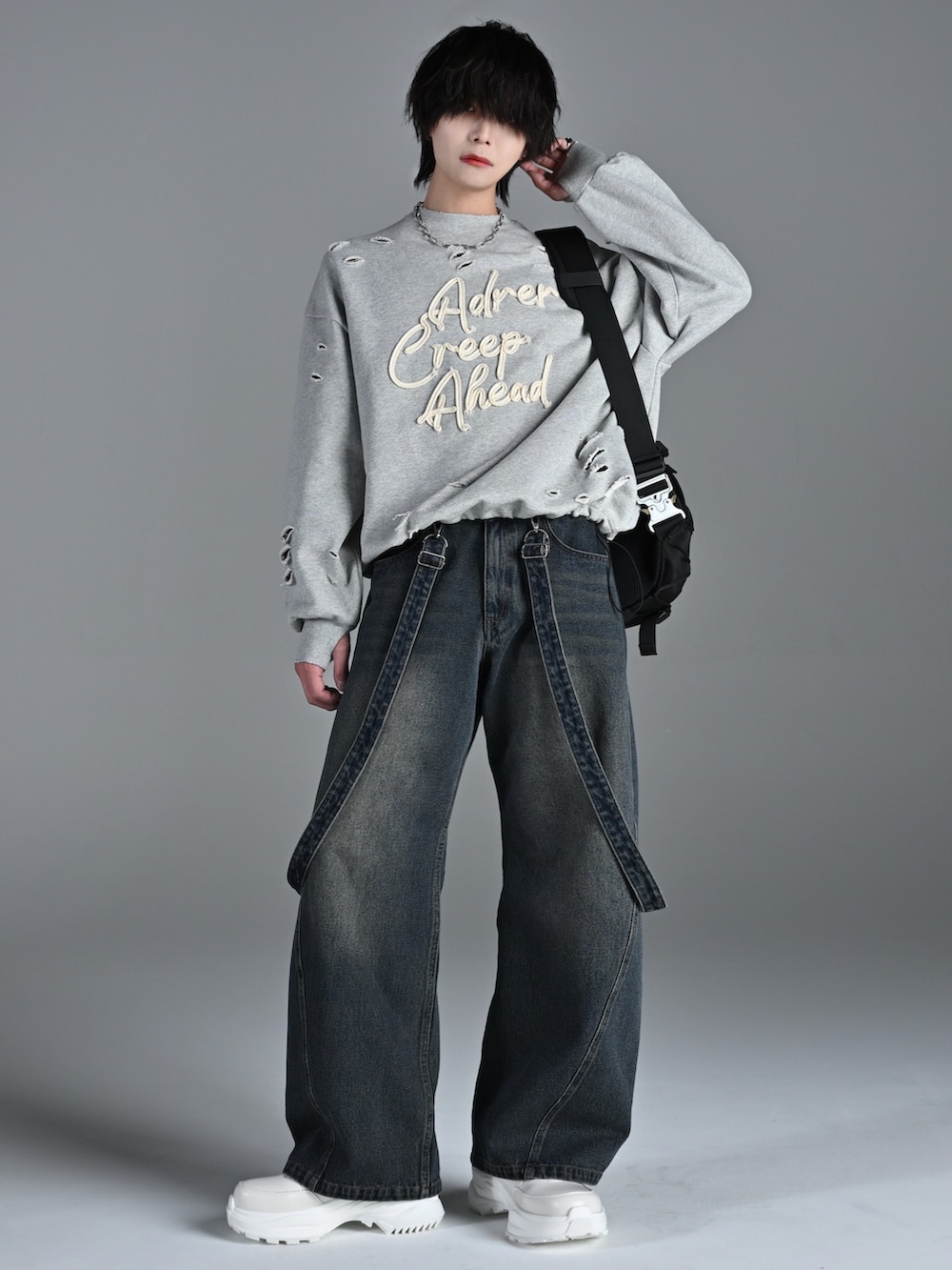 グレー系のスウェット、ブルー系のデニムパンツ、ホワイト系のスニーカーを着用したメンズの冬コーディネートの5枚目の写真