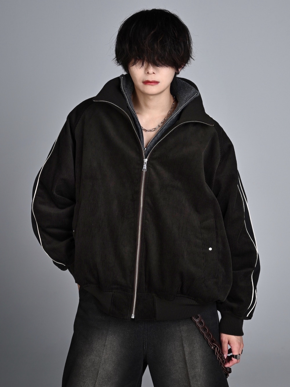 ホワイト系のスニーカー、ブラック系のその他パンツ、ブラウン系のブルゾンを着用したメンズの秋コーディネートの2枚目の写真