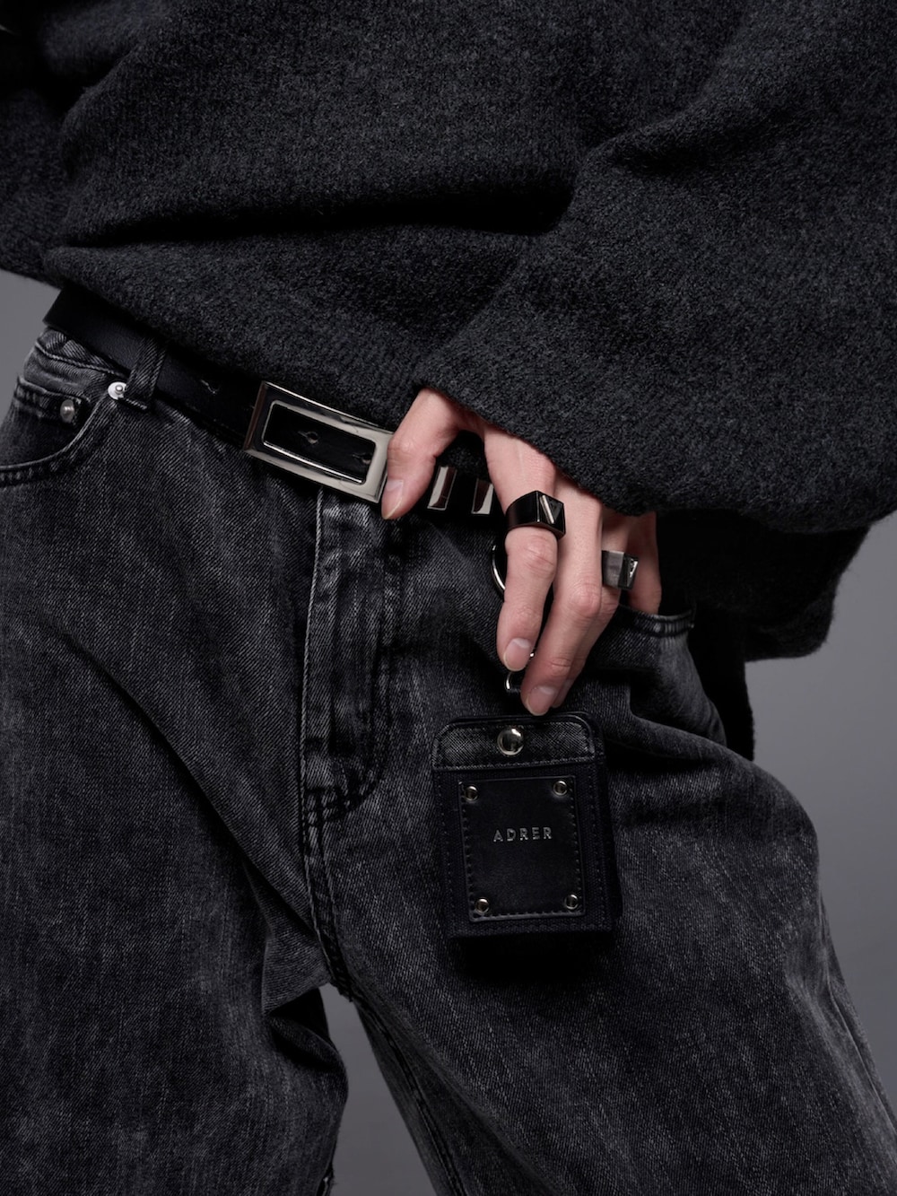 ブラック系のデニムパンツ、ブラック系のローファー、ブラック系のニット/セーターを着用したメンズの秋コーディネートの3枚目の写真