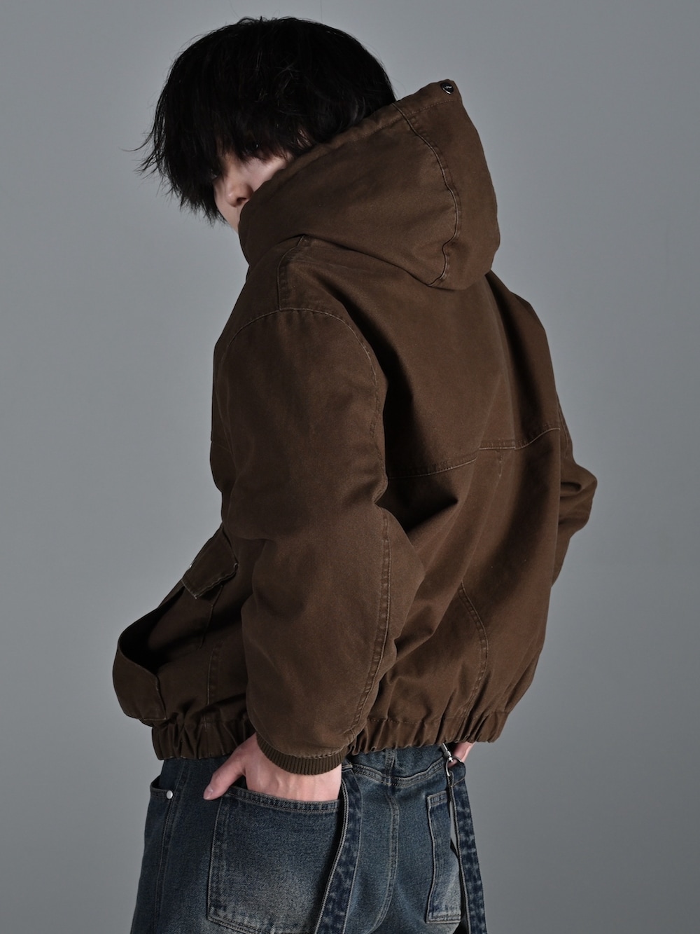 ブラウン系のブルゾン、グレー系のスウェット、ブルー系のデニムパンツを着用したメンズの冬コーディネートの3枚目の写真