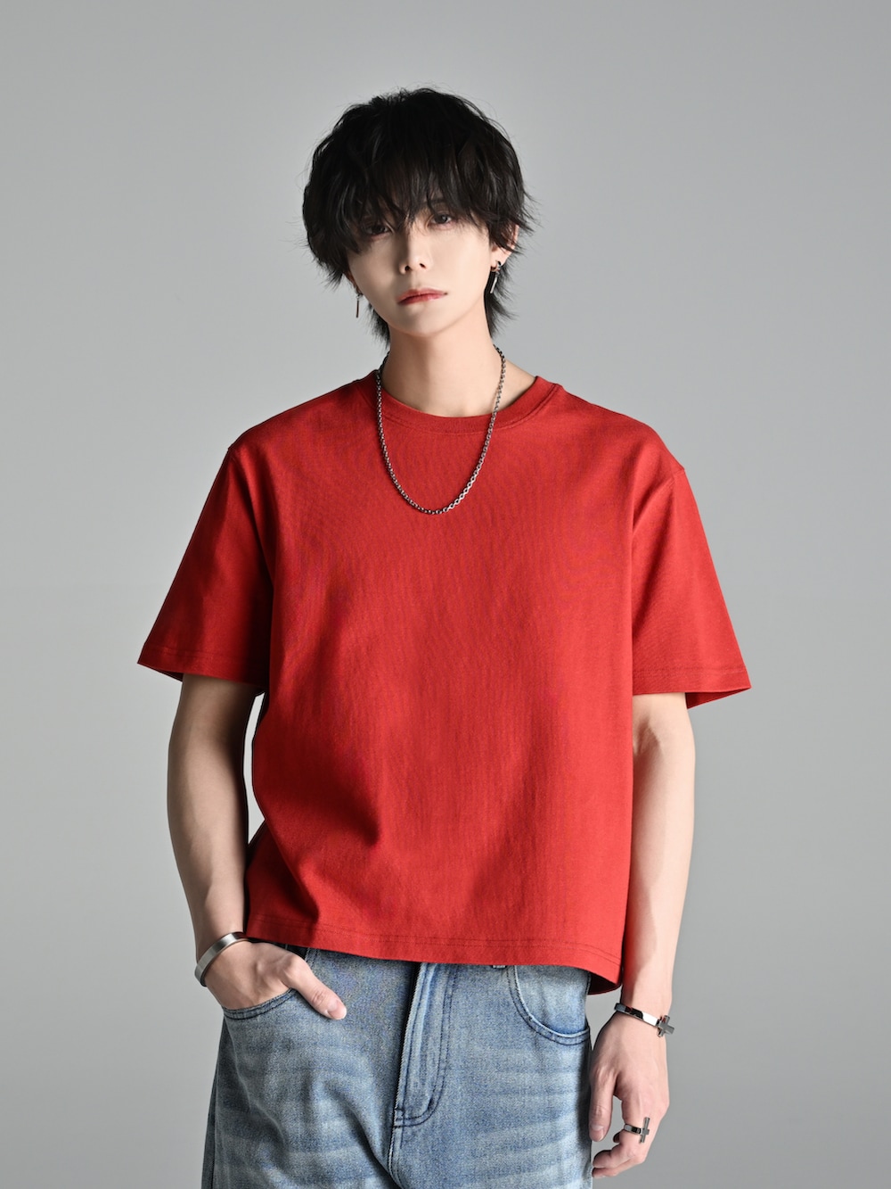 ブルー系のデニムパンツ、レッド系のTシャツ/カットソー、ブラウン系のブーツを着用したメンズの春コーディネートの2枚目の写真