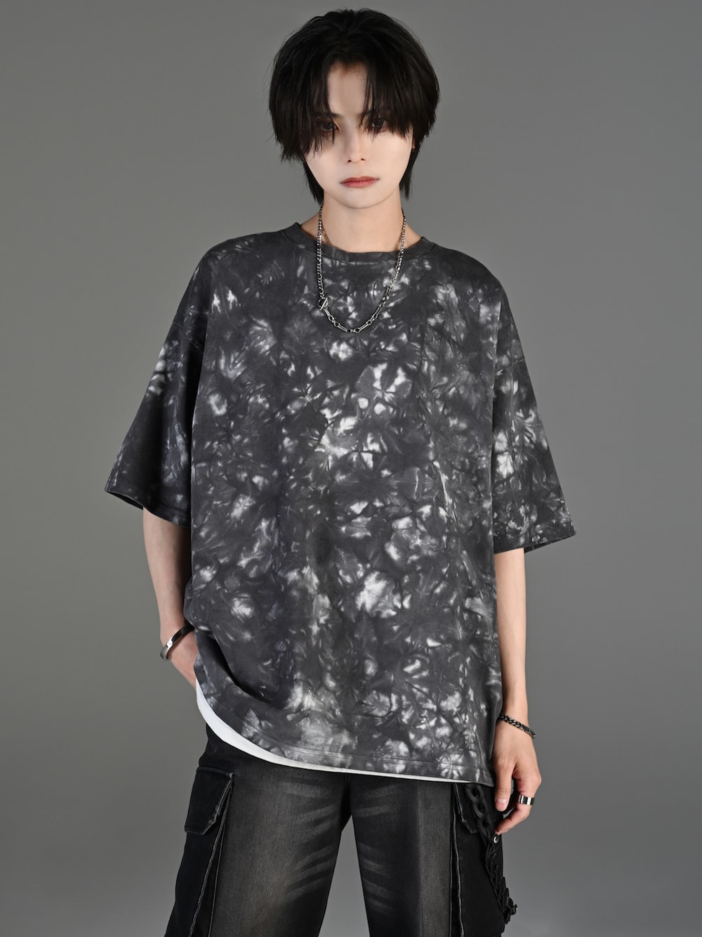 ブラック系のカーゴパンツ、ブラック系のスニーカー、ブラック系のショルダーバッグを着用したメンズの春コーディネートの3枚目の写真