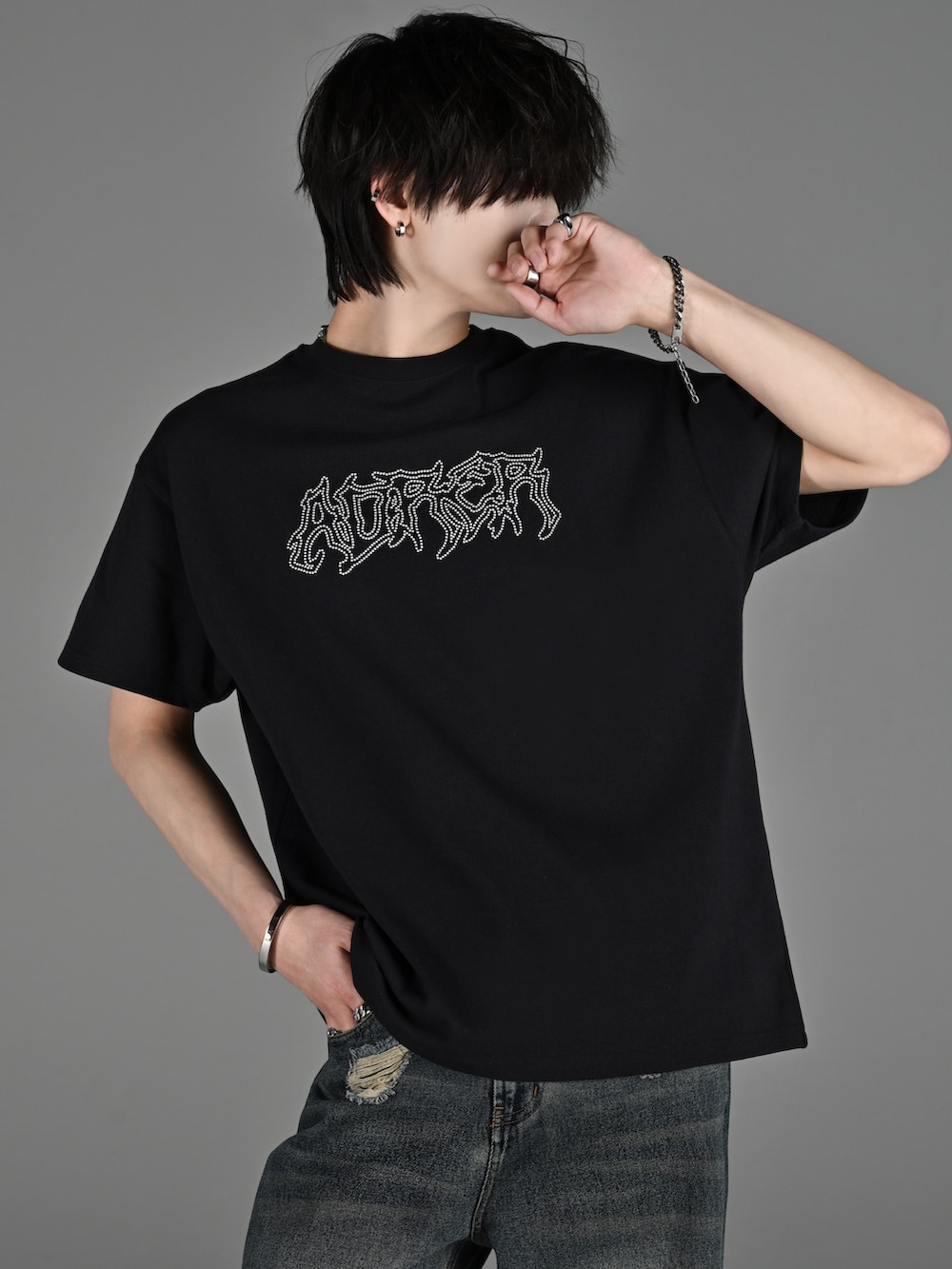 ブラック系のスニーカー、ブラック系のTシャツ/カットソー、ブラック系のデニムパンツを着用したメンズの春コーディネートの3枚目の写真