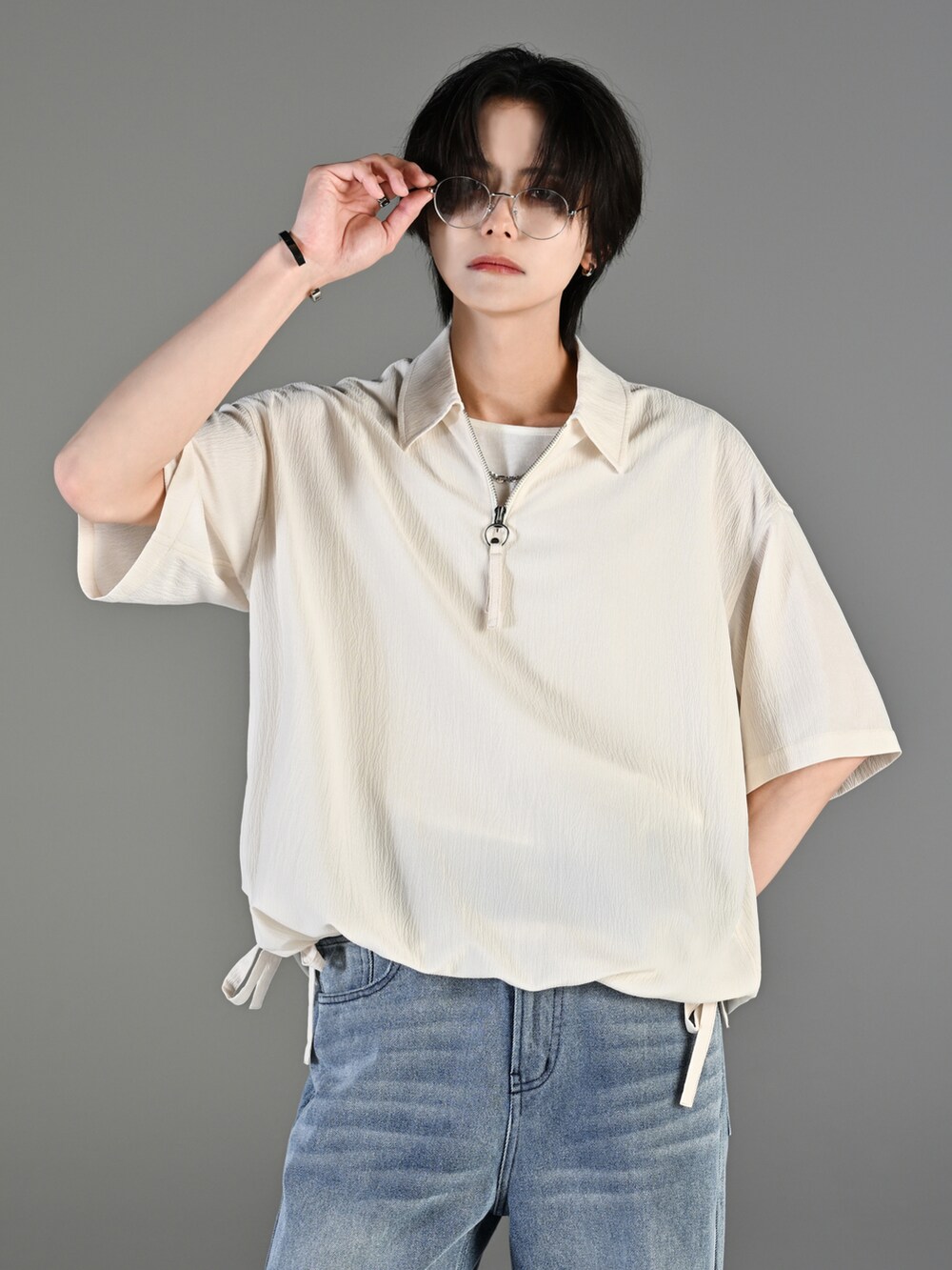 グレー系のタンクトップ、ブルー系のデニムパンツ、ホワイト系のスニーカーを着用したメンズの春コーディネートの5枚目の写真