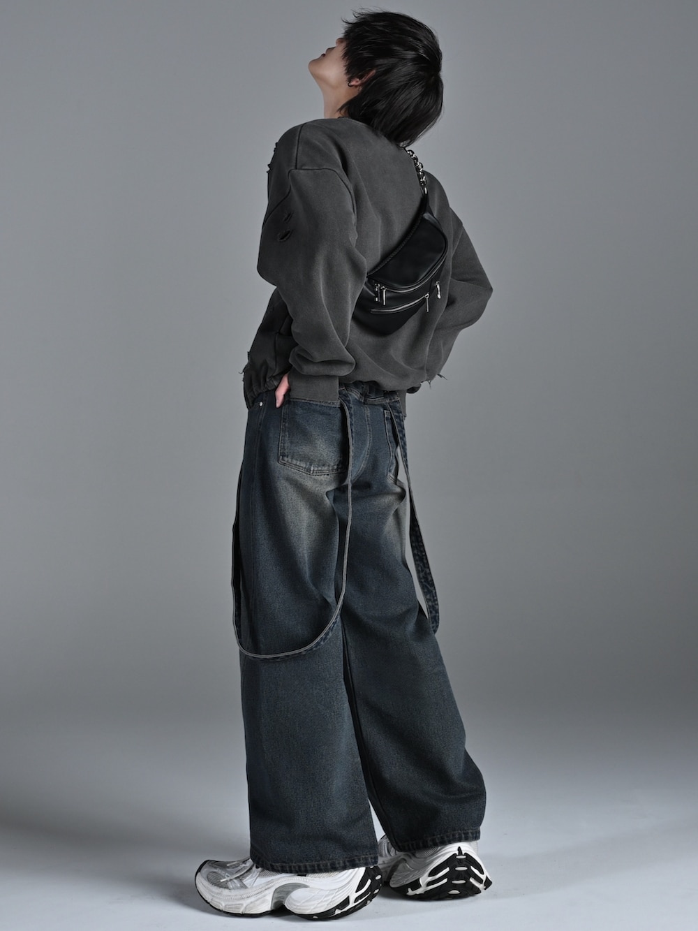 ブラック系のスニーカー、ブルー系のデニムパンツ、グレー系のスウェットを着用したメンズの冬コーディネートの2枚目の写真