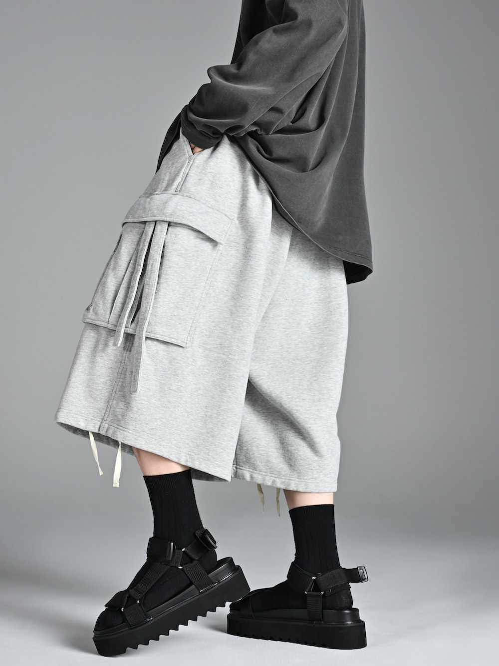 グレー系のTシャツ/カットソー、ブラック系のサンダル、グレー系のカーゴパンツを着用したメンズの夏コーディネートの3枚目の写真