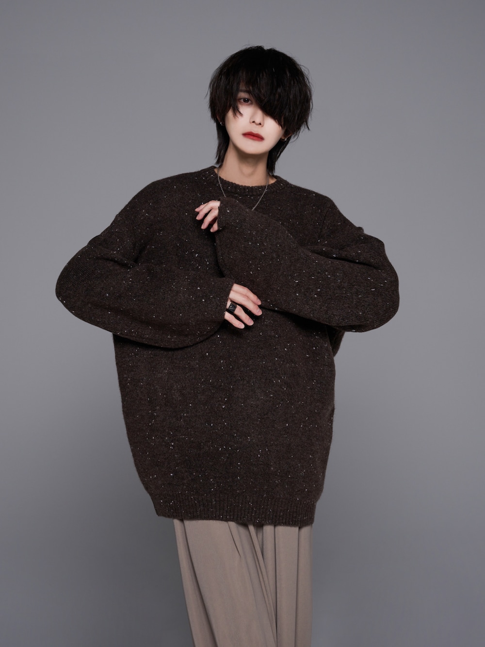 ベージュ系のスラックス、ブラック系のブーツ、ブラウン系のニット/セーターを着用したメンズの秋コーディネートの2枚目の写真