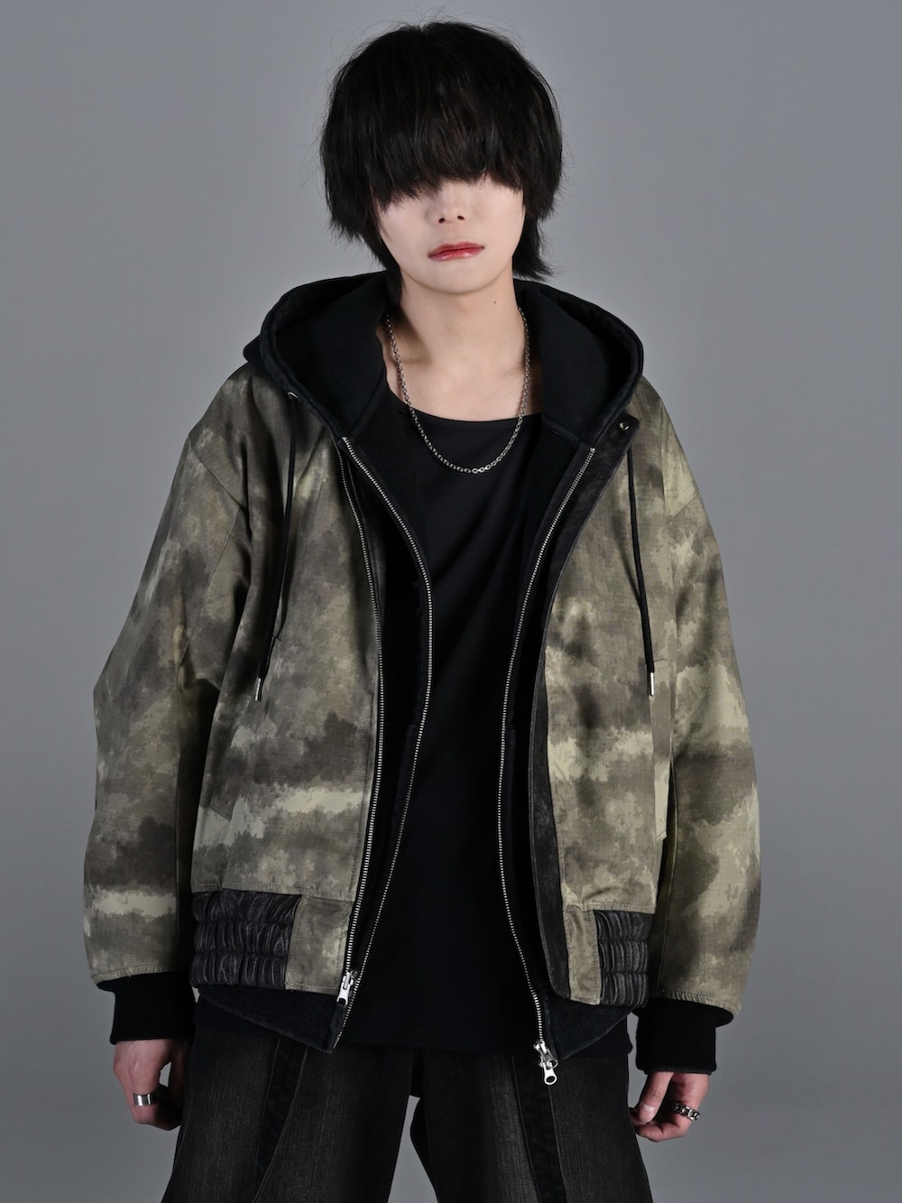 ブラック系のデニムパンツ、ブラック系のブーツ、レッド系のタンクトップを着用したメンズの冬コーディネートの3枚目の写真