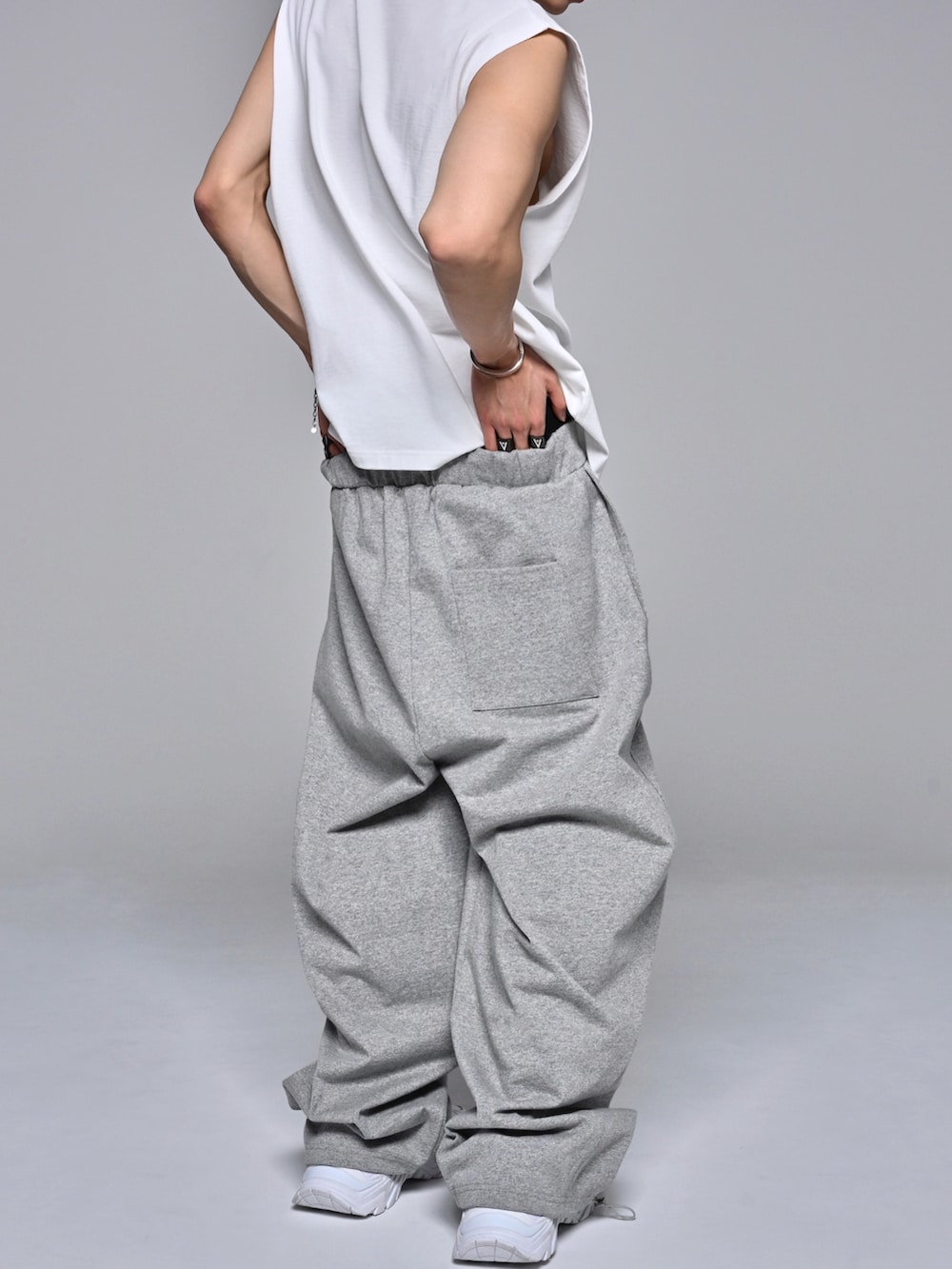 ホワイト系のタンクトップ、ホワイト系のスニーカー、グレー系のスウェットパンツを着用したメンズの夏コーディネートの5枚目の写真