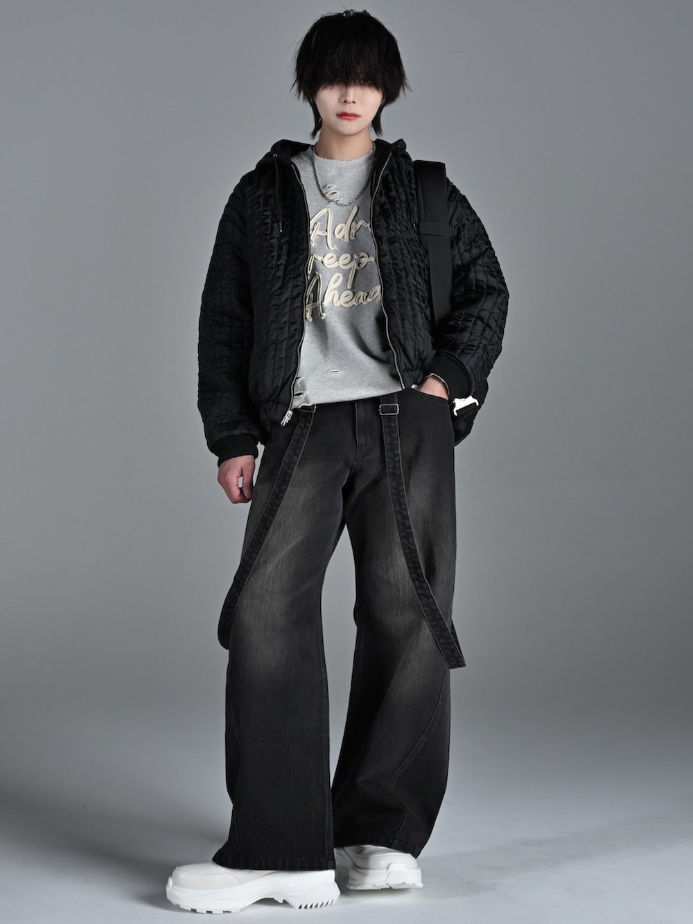 ホワイト系のスニーカー、ブラック系のブルゾン、グレー系のスウェットを着用したメンズの冬コーディネートの3枚目の写真