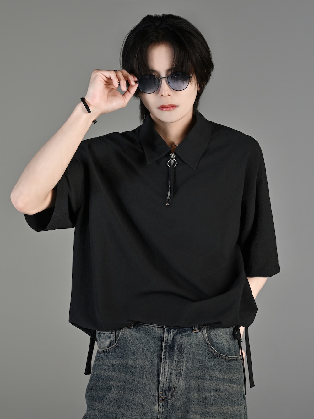 ブルー系のデニムパンツ、ブラック系のブーツ、ブラック系のショルダーバッグを着用したメンズの春コーディネートの3枚目の写真