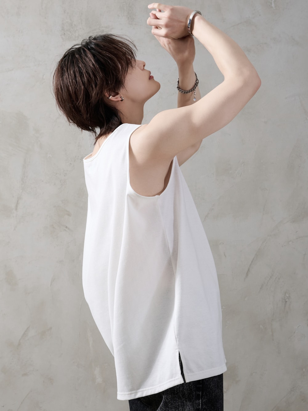 ブラック系のデニムパンツ、ブラック系のブーツ、ブラック系のショルダーバッグを着用したメンズの春コーディネートの3枚目の写真