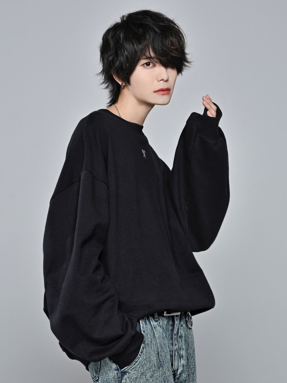 ブラック系のスウェット、ベージュ系のデニムパンツ、ブラック系のスニーカーを着用したメンズの冬コーディネートの4枚目の写真