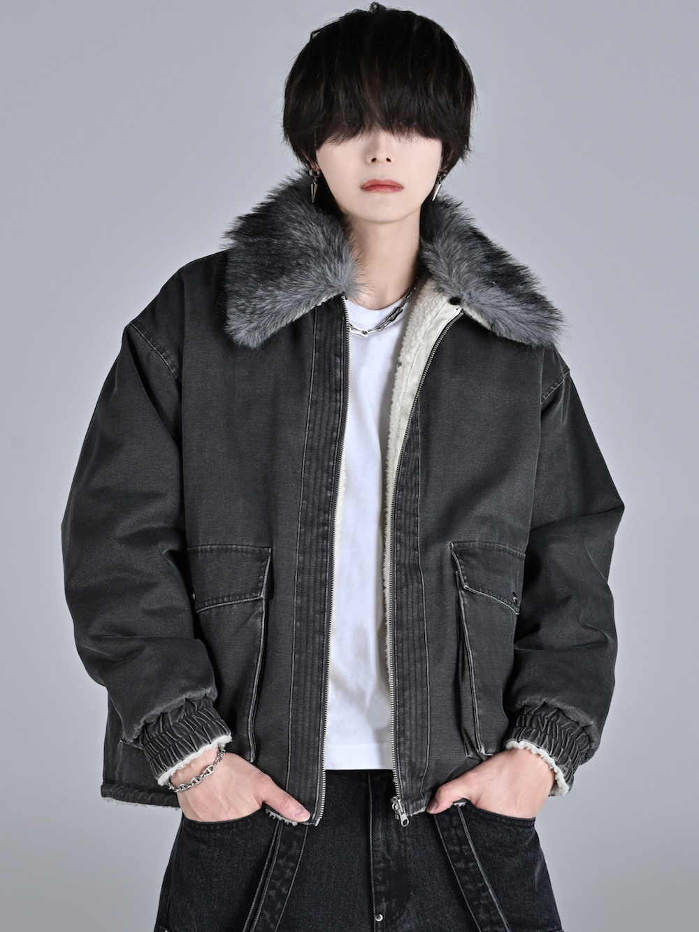 ブラック系のブルゾン、ブラック系のデニムパンツ、ホワイト系のスニーカーを着用したメンズの秋コーディネートの2枚目の写真