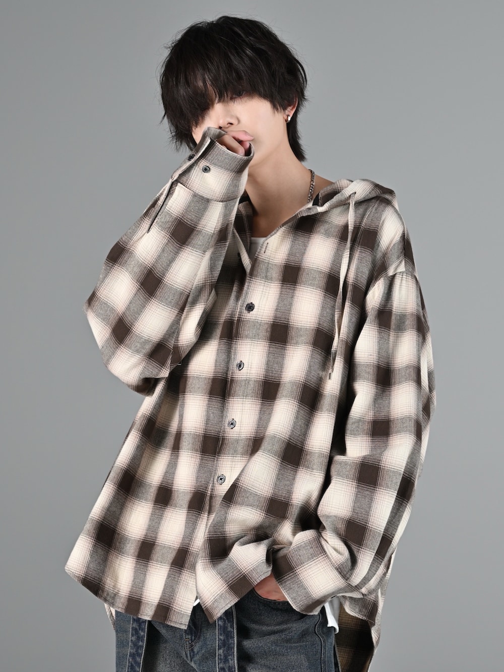 グレー系のタンクトップ、ブルー系のデニムパンツ、ブラック系のブーツを着用したメンズの冬コーディネートの2枚目の写真