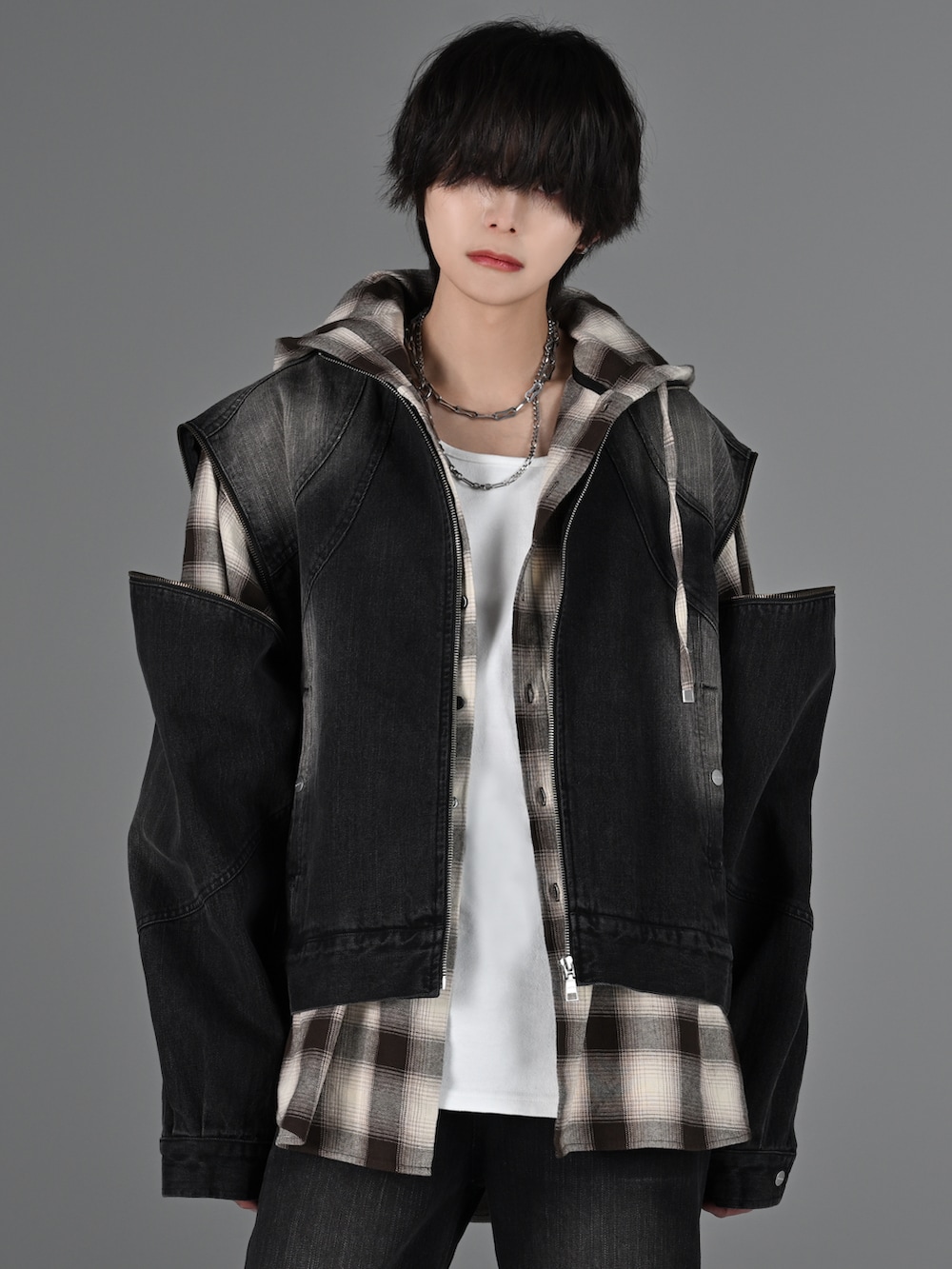 グレー系のタンクトップ、ブラック系のデニムパンツ、ホワイト系のスニーカーを着用したメンズの冬コーディネートの3枚目の写真