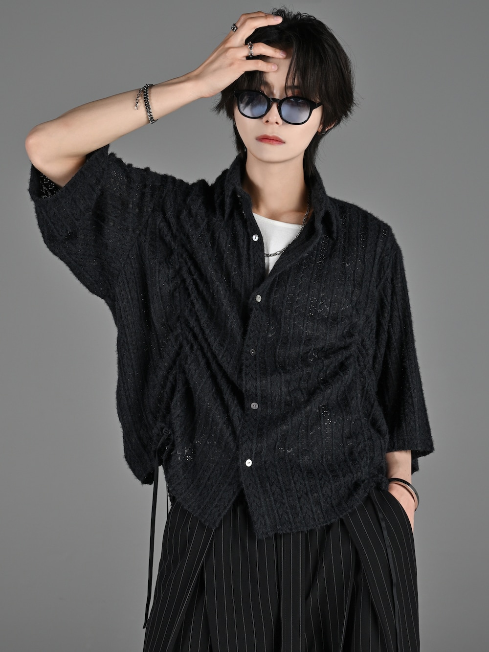 ブラック系のブーツ、グレー系のタンクトップ、ブラック系のスラックスを着用したメンズの春コーディネートの2枚目の写真