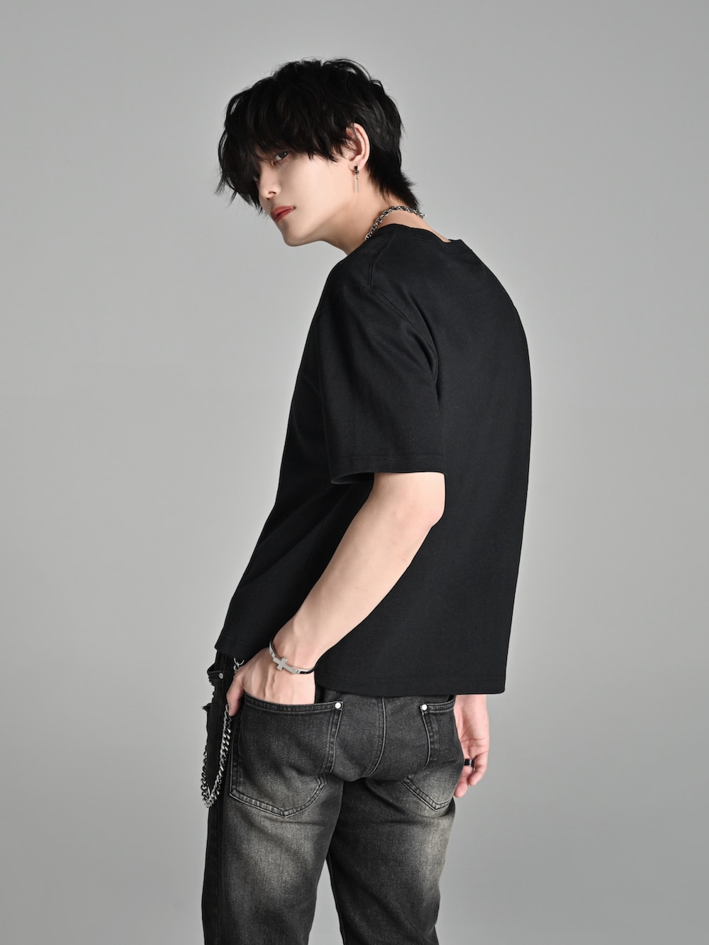 ブラック系のデニムパンツ、ブラック系のブーツ、ブラック系のTシャツ/カットソーを着用したメンズの春コーディネートの3枚目の写真