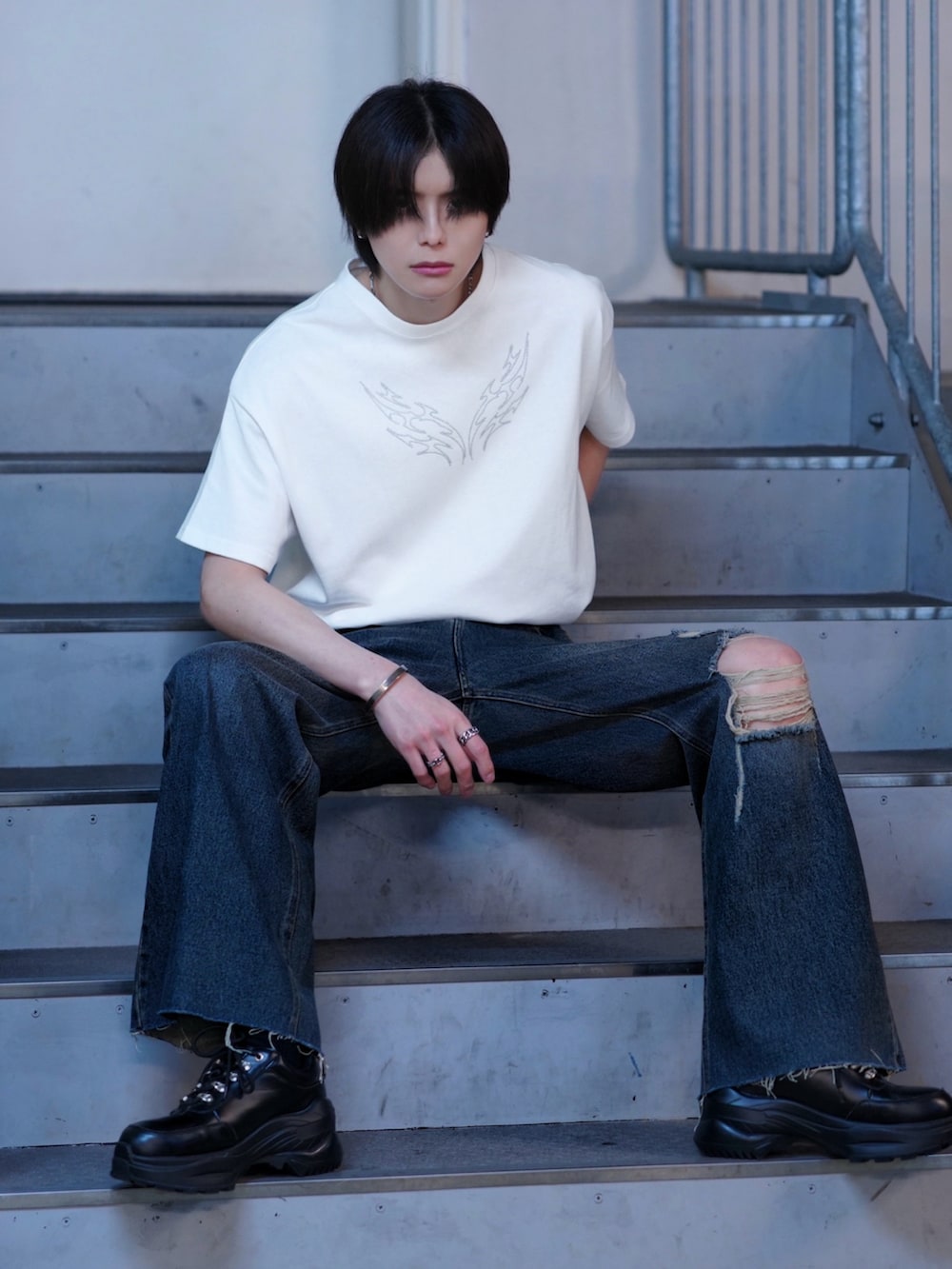 ブラック系のスニーカー、ホワイト系のTシャツ/カットソー、ブルー系のデニムパンツを着用したメンズの春コーディネートの5枚目の写真