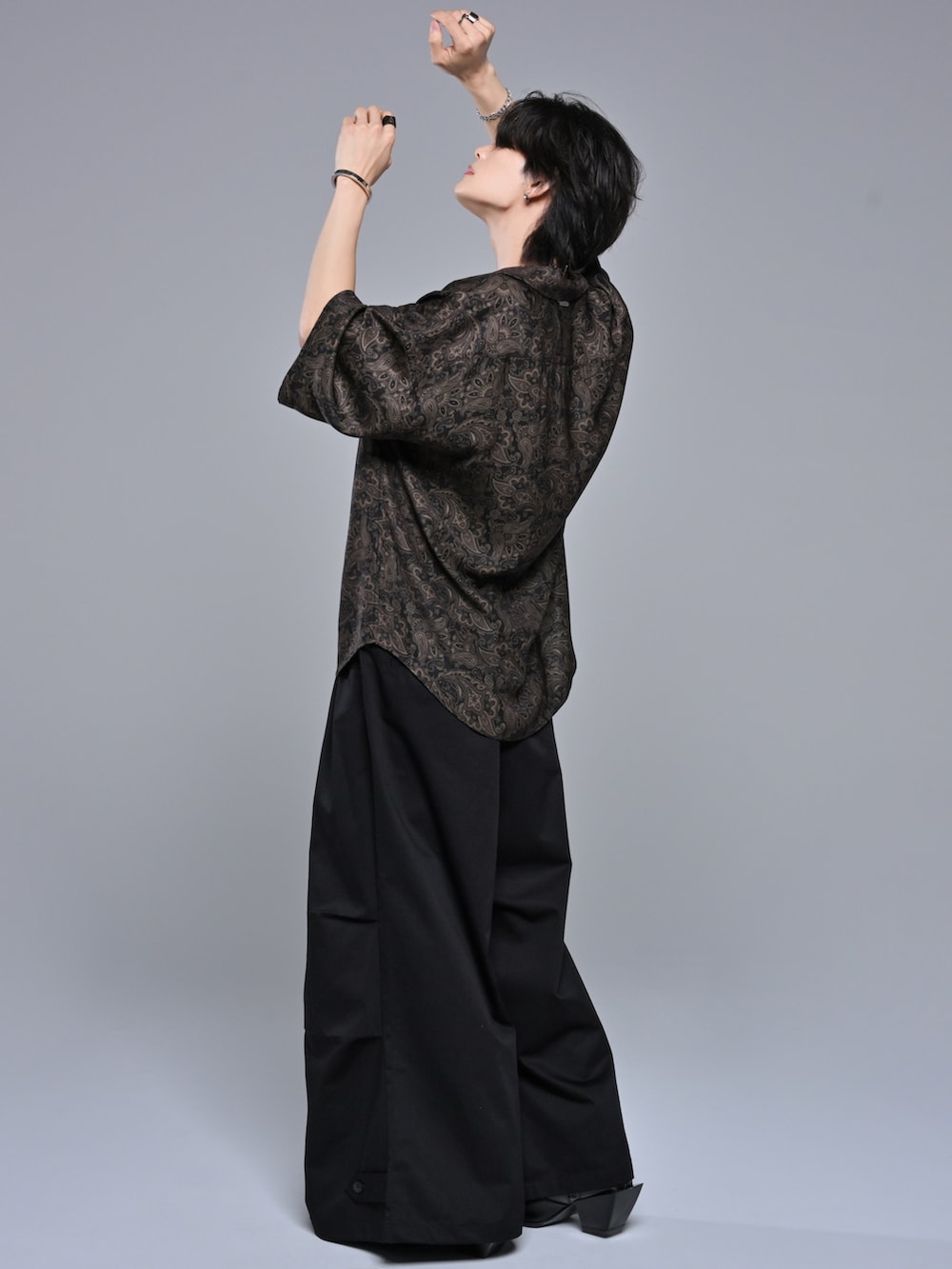 ブラック系のスラックス、ブラック系のブーツ、ブラック系のシャツ/ブラウスを着用したメンズの春コーディネートの2枚目の写真