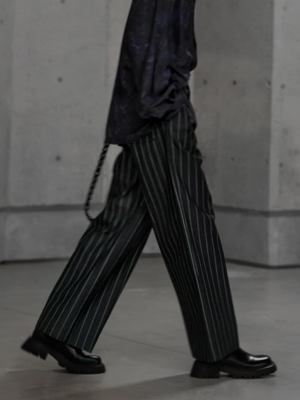 ブラック系のブーツ、ブラック系のテーラードジャケット、ブラック系のスラックスを着用したメンズの冬コーディネートの4枚目の写真