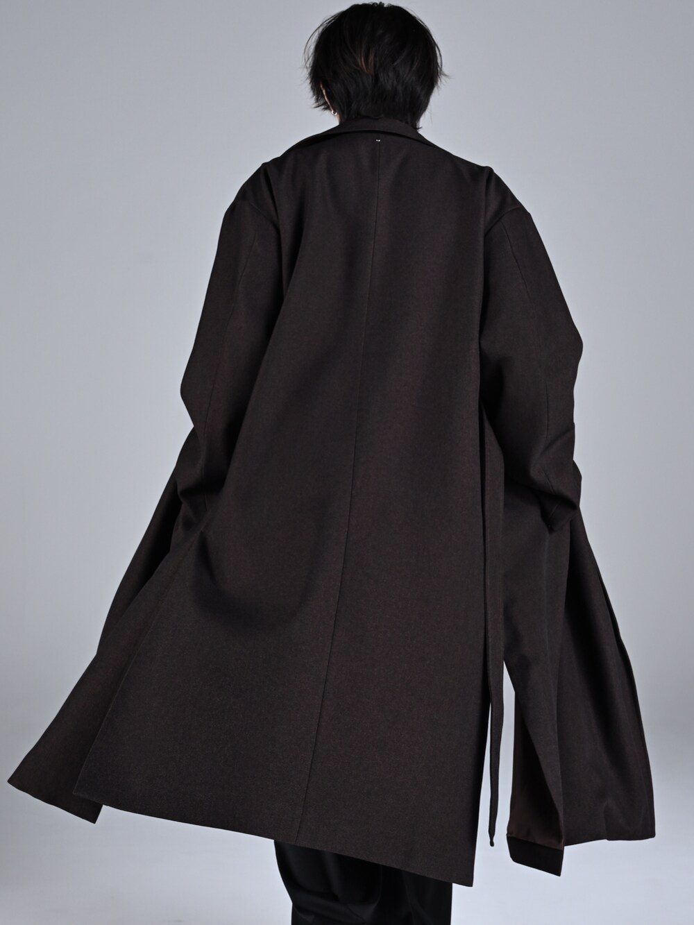 ブラック系のブーツ、ホワイト系のニット/セーター、ブラック系のスラックスを着用したメンズの秋コーディネートの5枚目の写真