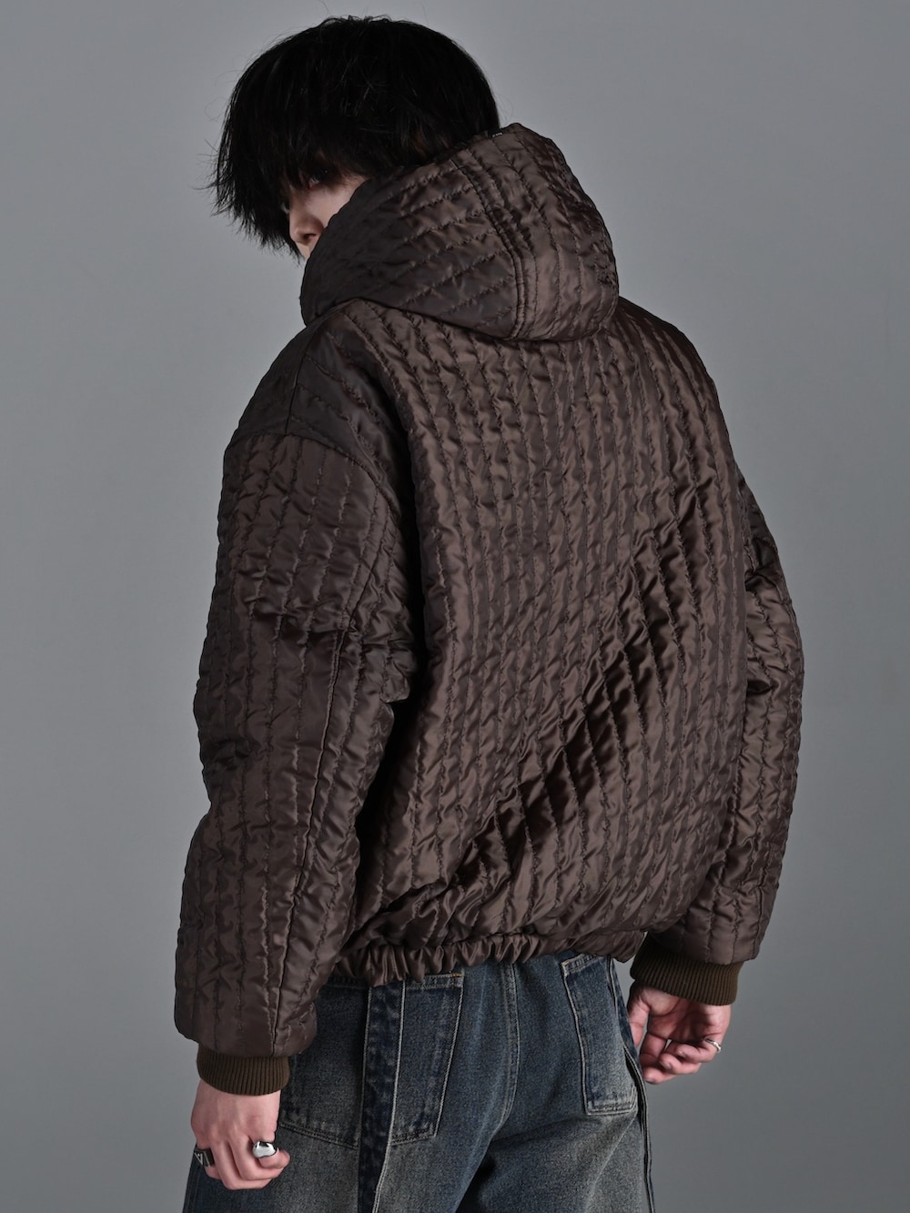 ブラウン系のブルゾン、グレー系のスウェット、ブルー系のデニムパンツを着用したメンズの冬コーディネートの5枚目の写真