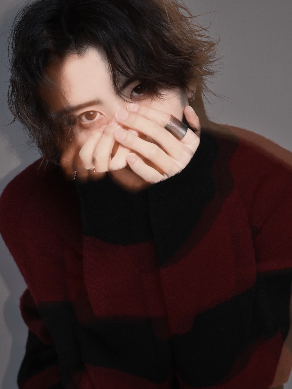 レッド系のニット/セーター、ブラック系のスラックス、ブラック系のスニーカーを着用したメンズの秋コーディネートの3枚目の写真