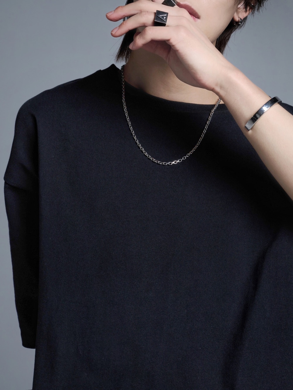 ブルー系のカーゴパンツ、ホワイト系のスニーカー、ブラック系のTシャツ/カットソーを着用したメンズの春コーディネートの2枚目の写真