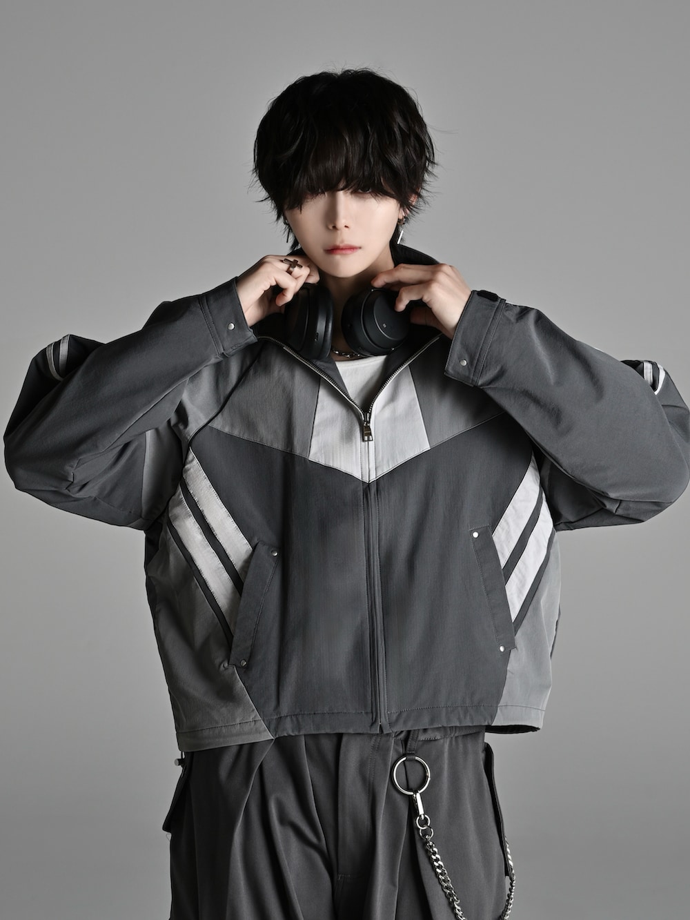 グレー系のカーゴパンツ、ブラック系のショルダーバッグ、ホワイト系のスニーカーを着用したメンズの冬コーディネートの4枚目の写真