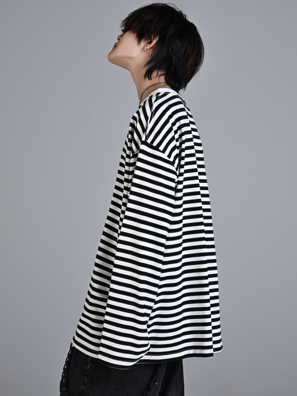 ブラック系のデニムパンツ、ホワイト系のスニーカー、ブラック系のショルダーバッグを着用したメンズの秋コーディネートの4枚目の写真