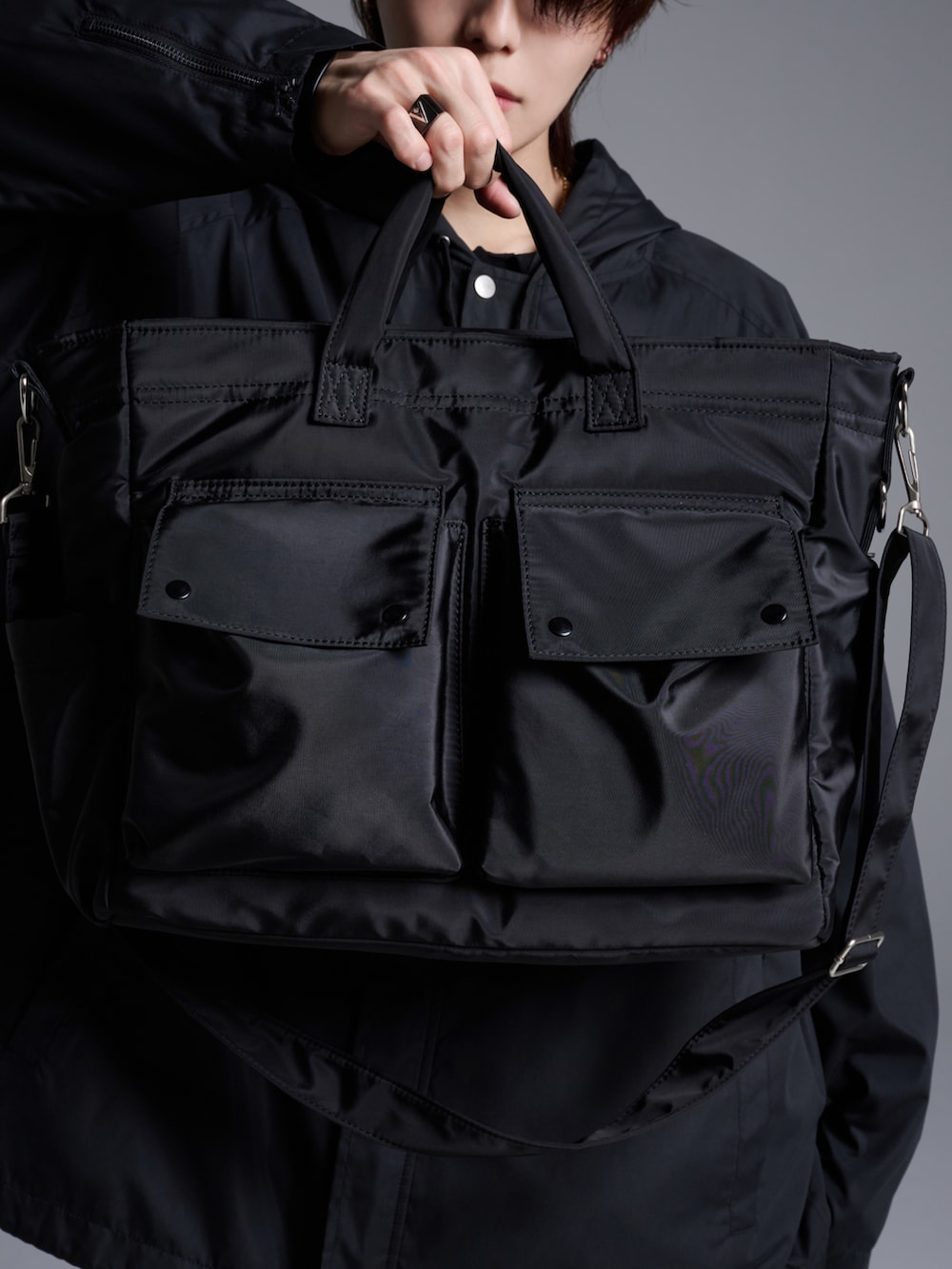 ブラック系のデニムパンツ、ブラウン系のポロシャツ、ブラック系のブーツを着用したメンズの冬コーディネートの4枚目の写真