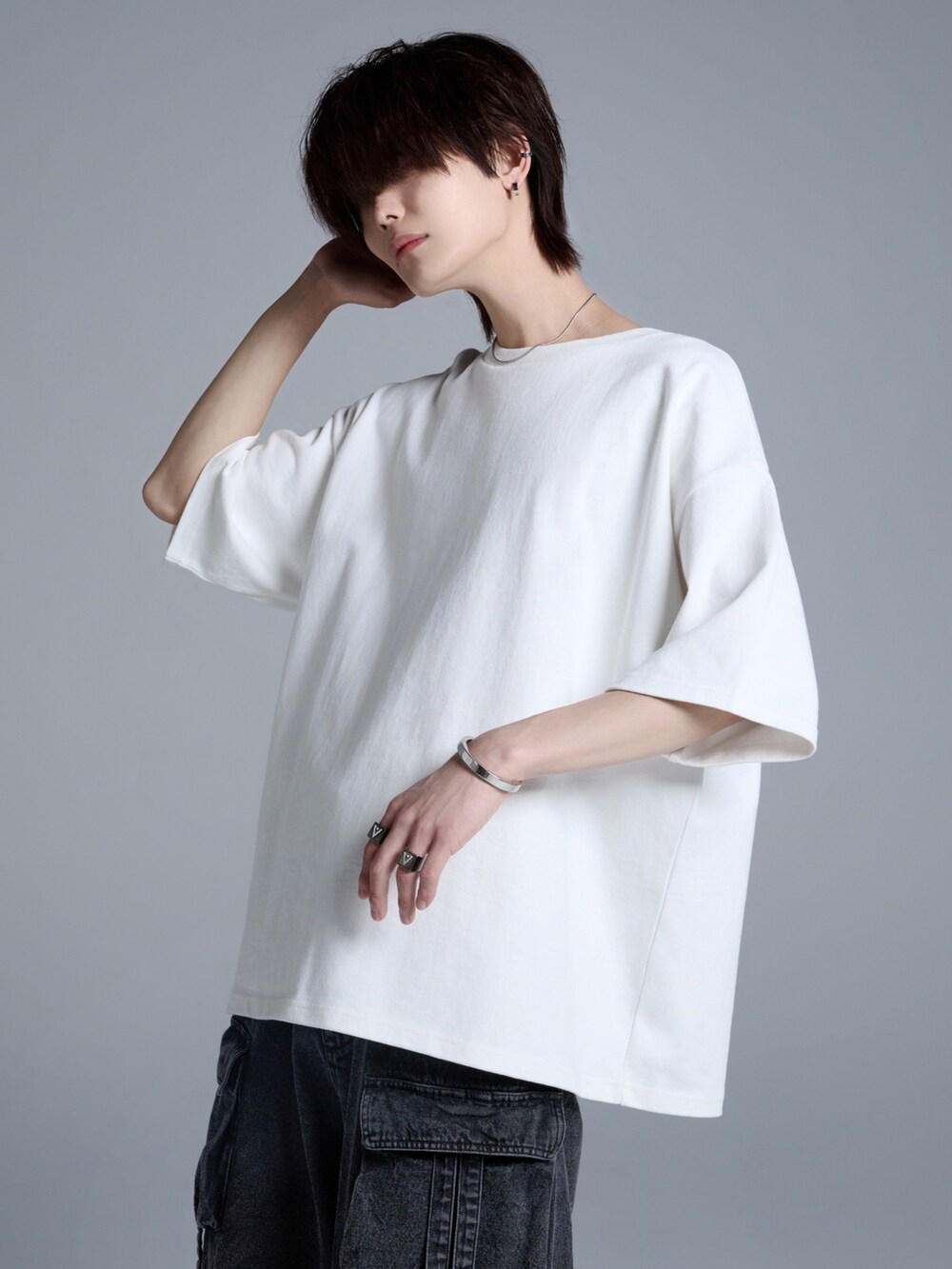ブラック系のカーゴパンツ、ブラック系のスニーカー、ホワイト系のTシャツ/カットソーを着用したメンズの春コーディネートの3枚目の写真