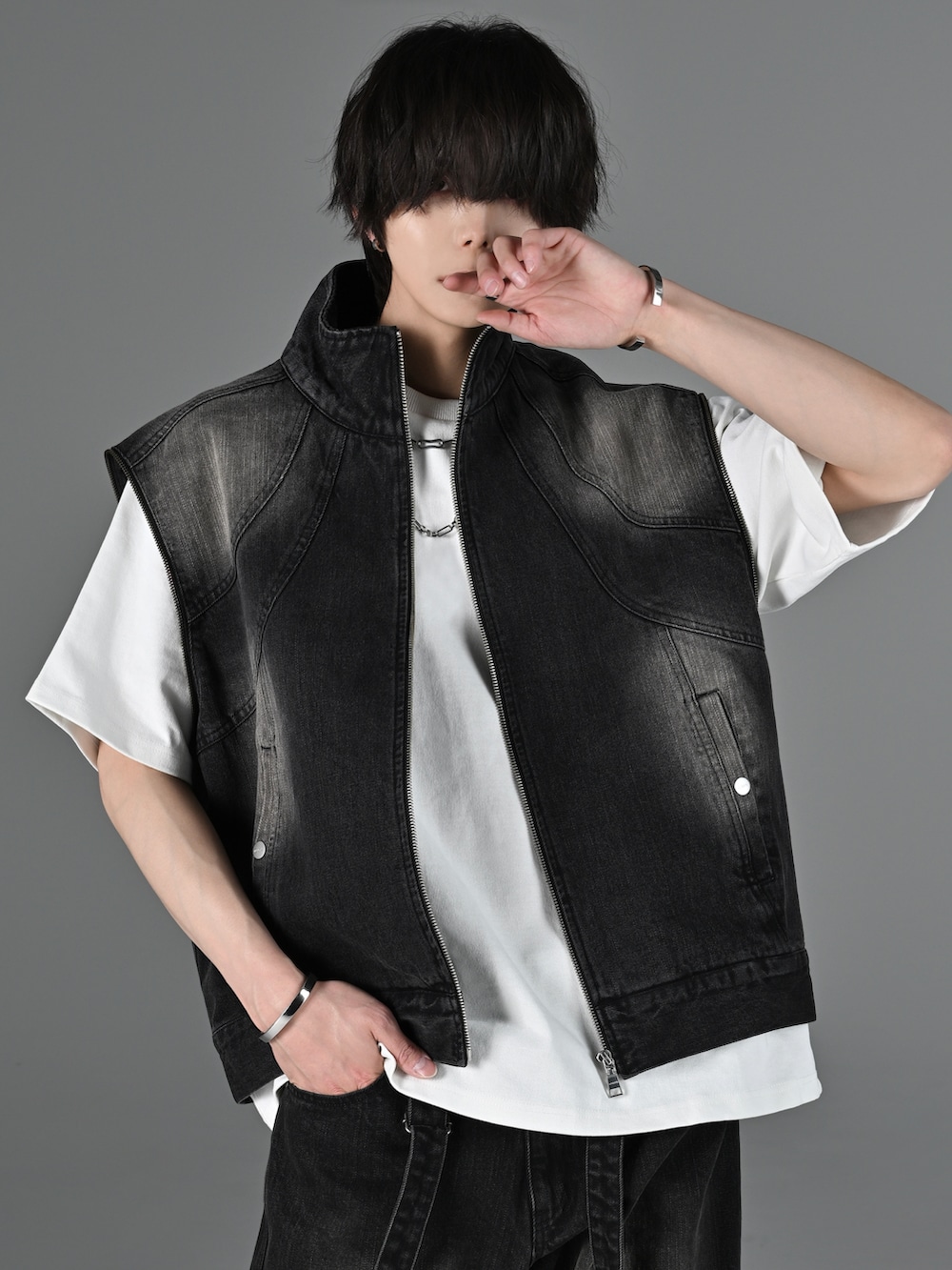 グレー系のタンクトップ、ブラック系のスラックス、ブラック系のブーツを着用したメンズの冬コーディネートの4枚目の写真