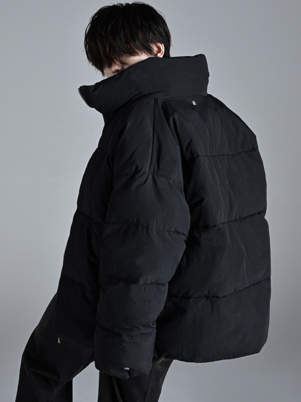 ブラック系のブーツ、ブラック系のダウンジャケット/コート、ブラック系のニット/セーターを着用したメンズの秋コーディネートの4枚目の写真