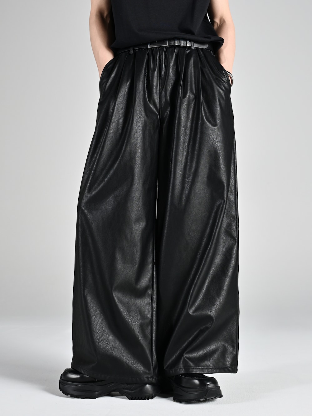 レッド系のタンクトップ、ブラック系のスニーカー、ブラック系のブルゾンを着用したメンズの夏コーディネートの5枚目の写真