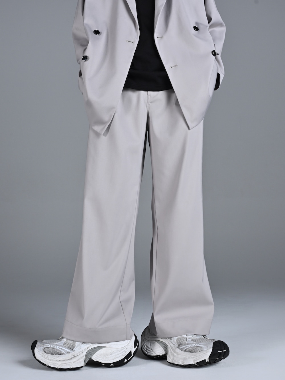 ホワイト系のスニーカー、レッド系のタンクトップ、グレー系のテーラードジャケットを着用したメンズの冬コーディネートの2枚目の写真