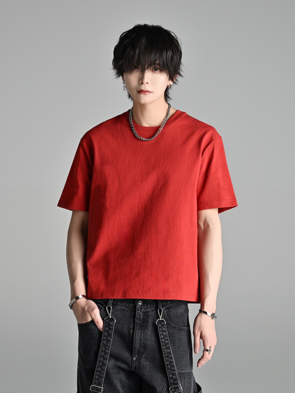 ブルー系のデニムパンツ、レッド系のTシャツ/カットソー、ブラウン系のブーツを着用したメンズの春コーディネートの4枚目の写真