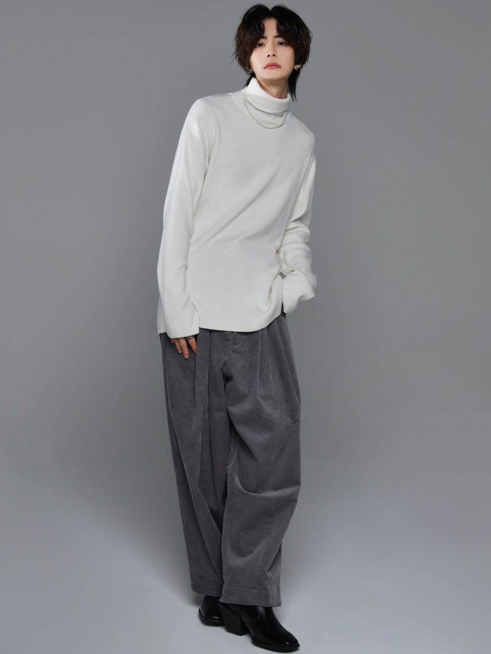 ブラック系のブーツ、ブラック系のニット/セーター、ブラック系のその他パンツを着用したメンズの秋コーディネートの3枚目の写真