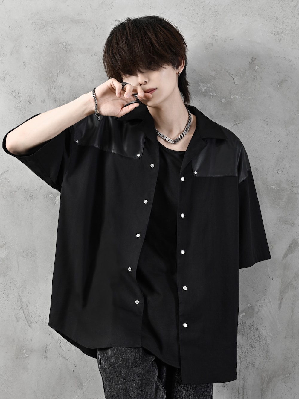 ブラック系のデニムパンツ、ブラック系のブーツ、ブラック系のショルダーバッグを着用したメンズの春コーディネートの3枚目の写真