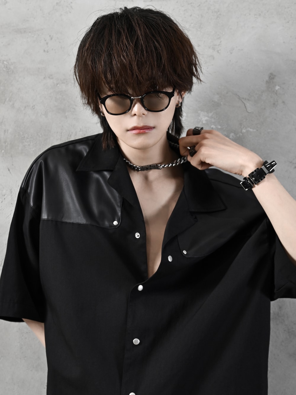 ブラック系のデニムパンツ、ブラック系のブーツ、ブラック系のショルダーバッグを着用したメンズの春コーディネートの2枚目の写真