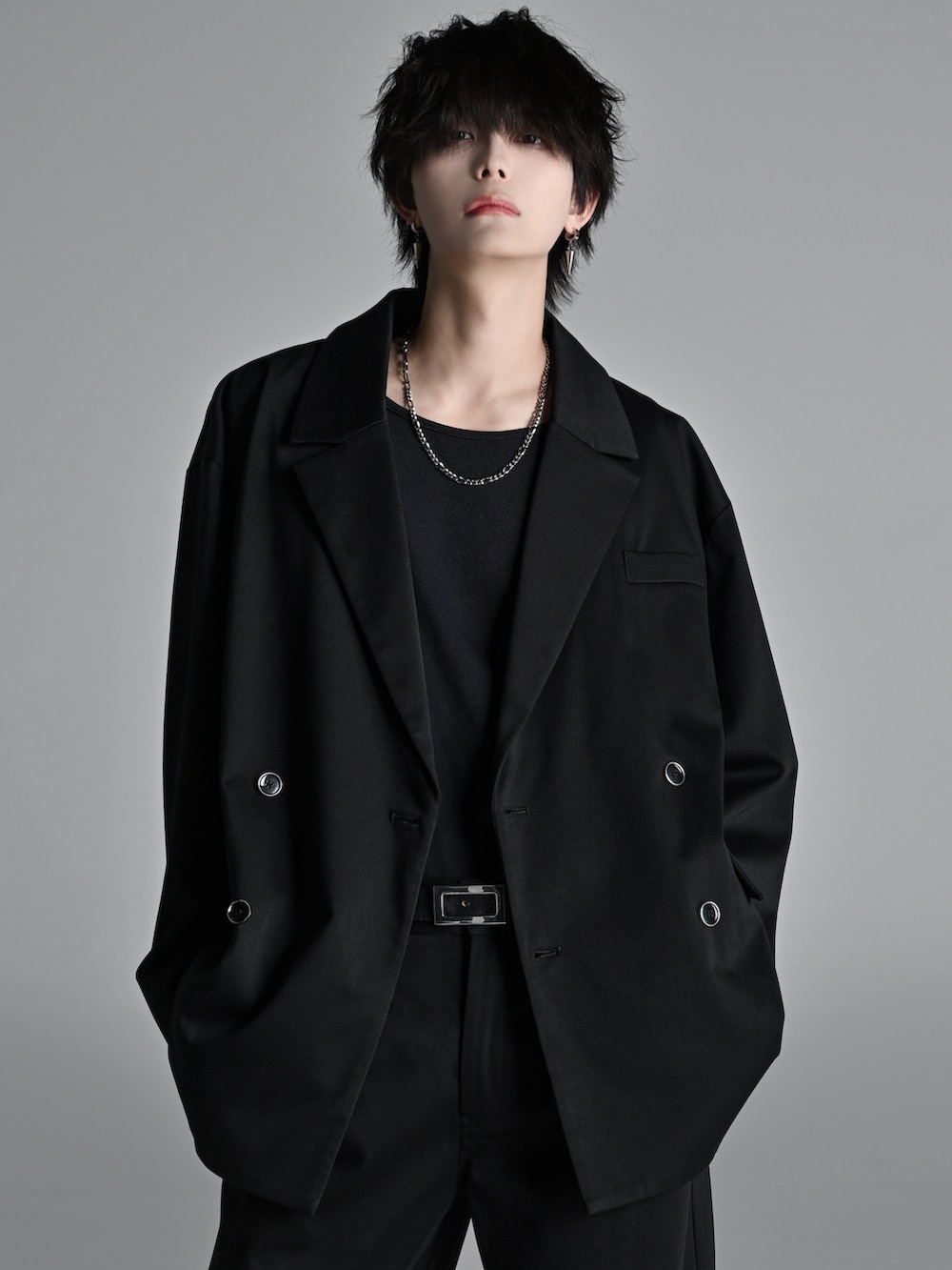 ブラック系のテーラードジャケット、レッド系のタンクトップ、ブラック系のスラックスを着用したメンズの冬コーディネートの2枚目の写真