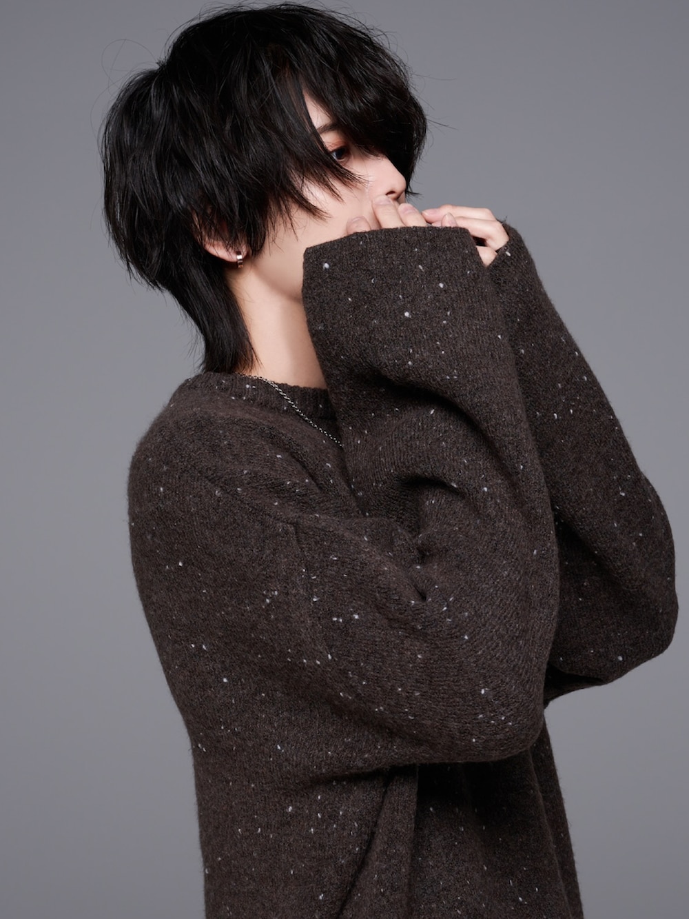 ベージュ系のスラックス、ブラック系のブーツ、ブラウン系のニット/セーターを着用したメンズの秋コーディネートの3枚目の写真