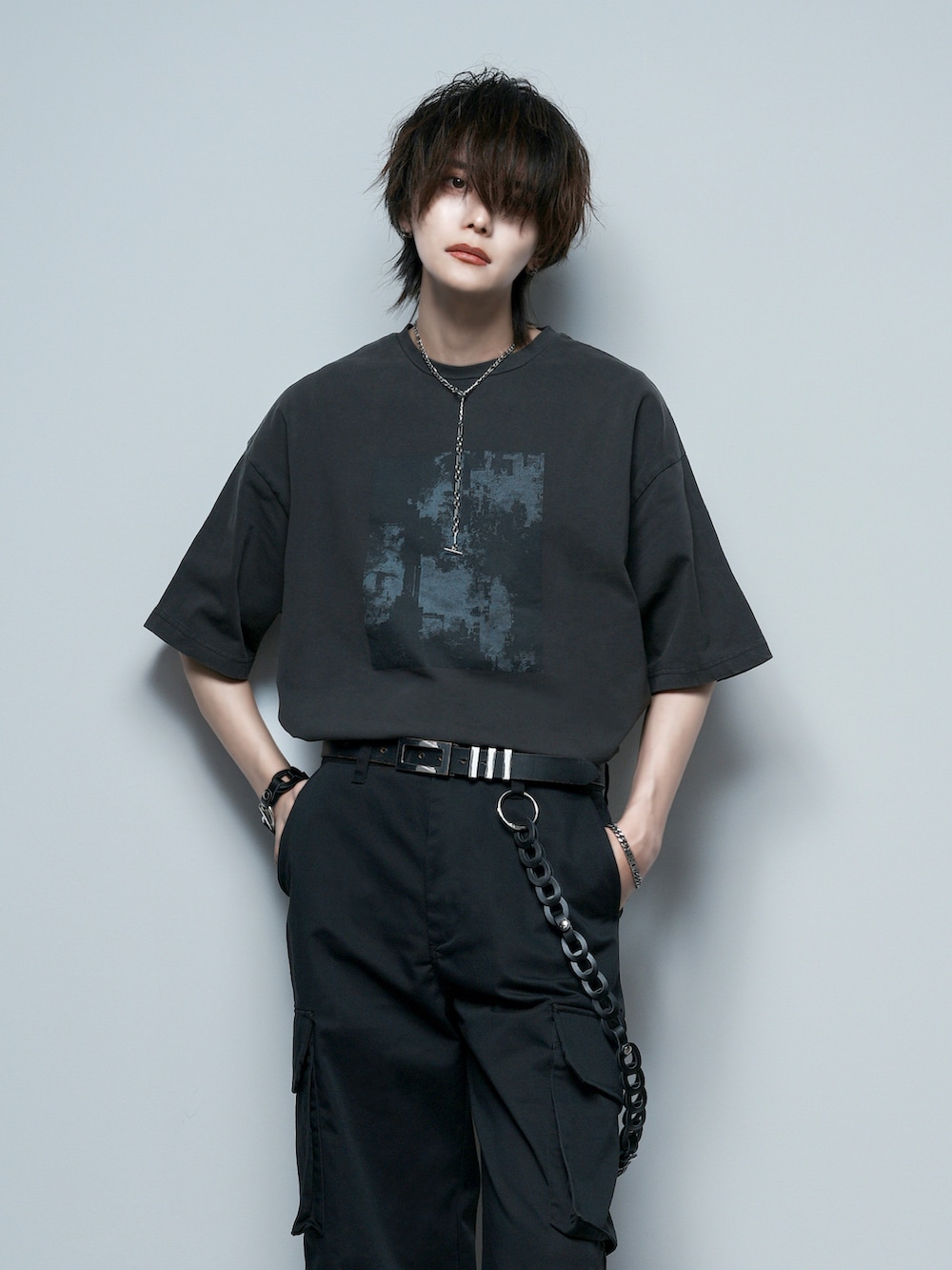 ブラック系のカーゴパンツ、ブラック系のブーツ、ホワイト系のタンクトップを着用したメンズの夏コーディネートの4枚目の写真