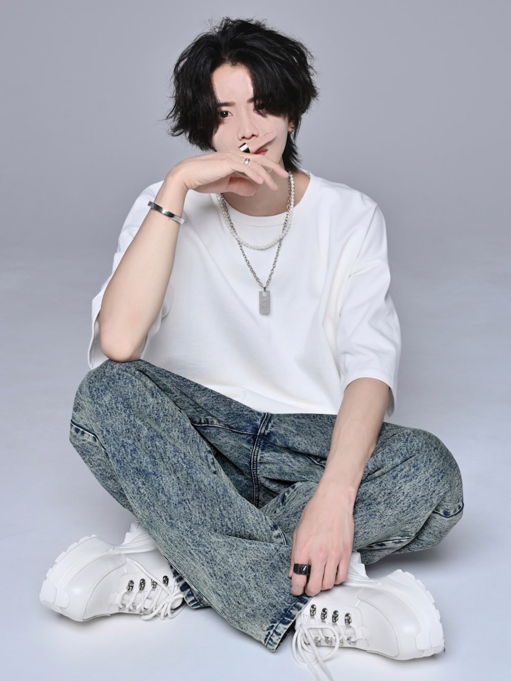 ホワイト系のスニーカー、ベージュ系のデニムパンツ、ホワイト系のTシャツ/カットソーを着用したメンズの春コーディネートの2枚目の写真