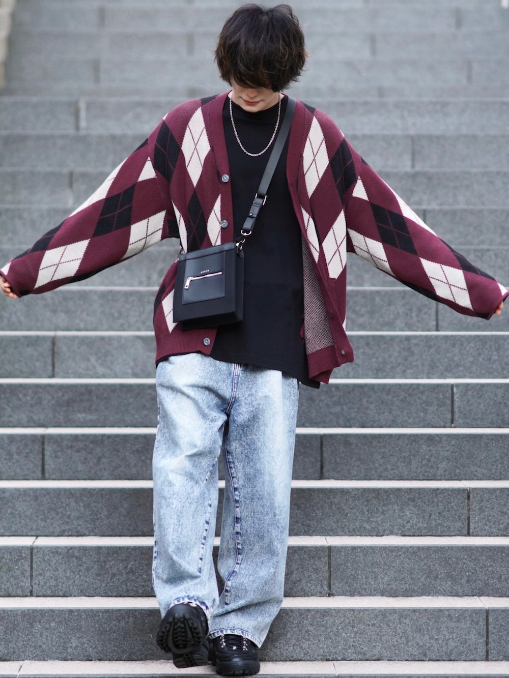 ブラック系のTシャツ/カットソー、ブルー系のデニムパンツ、ブラック系のスニーカーを着用したメンズの秋コーディネートの3枚目の写真