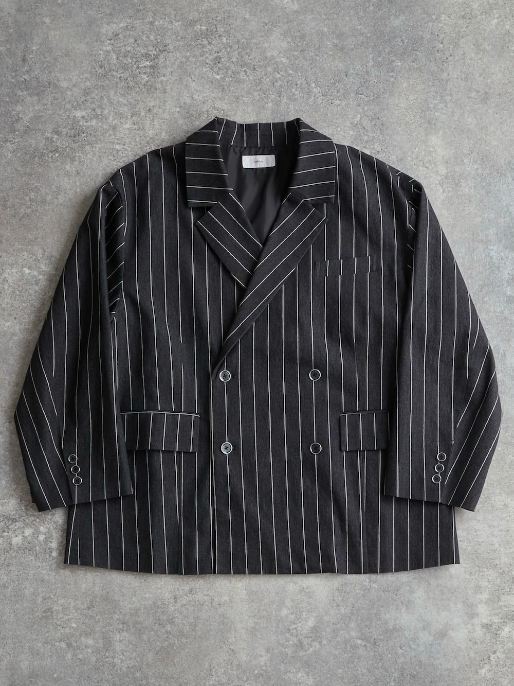 ブラック系のブーツ、レッド系のタンクトップ、ブラック系のテーラードジャケットを着用したメンズの冬コーディネートの3枚目の写真